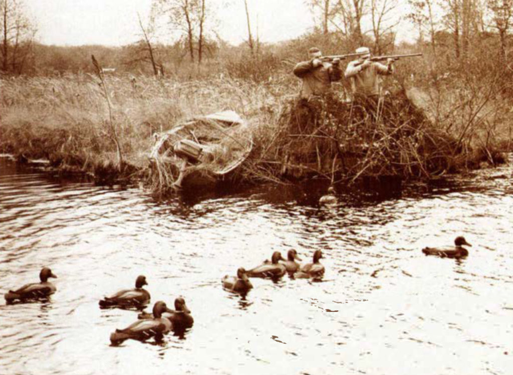Isang imahe ng dalawang mangangaso sa harap ng isang ilog na puno ng tubig