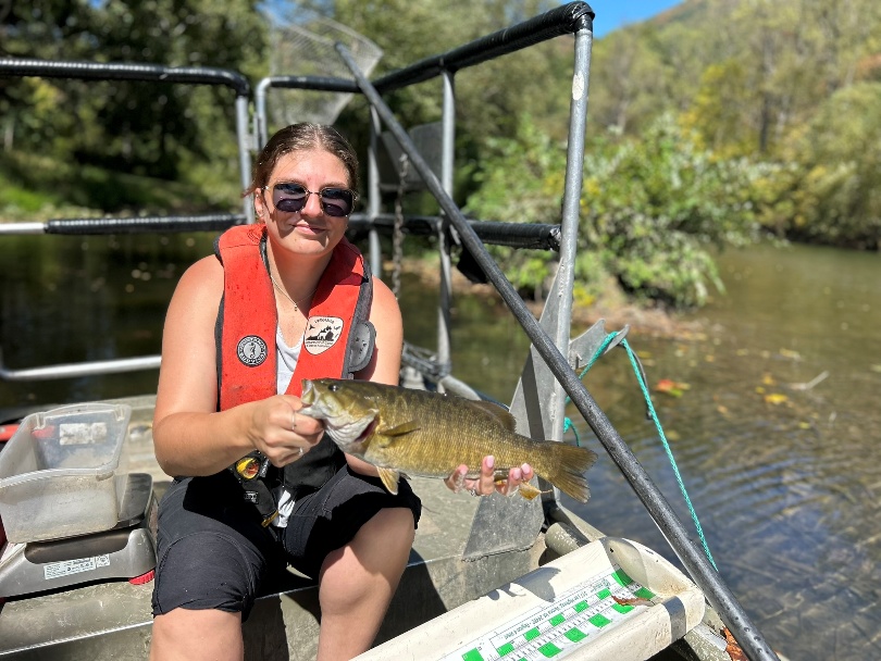 Mangingisda sa isang bangka na may hawak na smallmouth bass mula sa Cowpasture River.