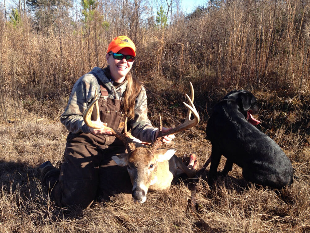 Sergeant Jessica Whirley at isang usa na kanyang nabaril na nag-pose sa tabi ng kanyang itim na lab