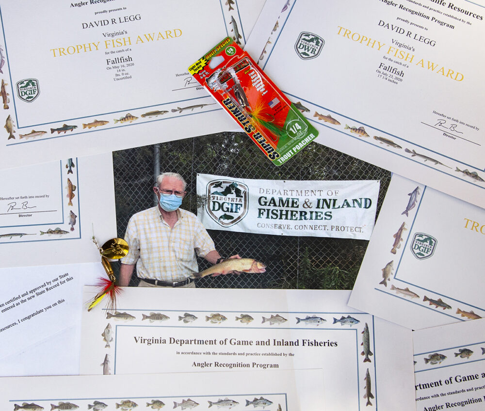 Isang imahe ng angler na nakakuha ng record breaking fallfish na napapaligiran ng maraming mga parangal na kanyang napanalunan sa mga nakaraang taon
