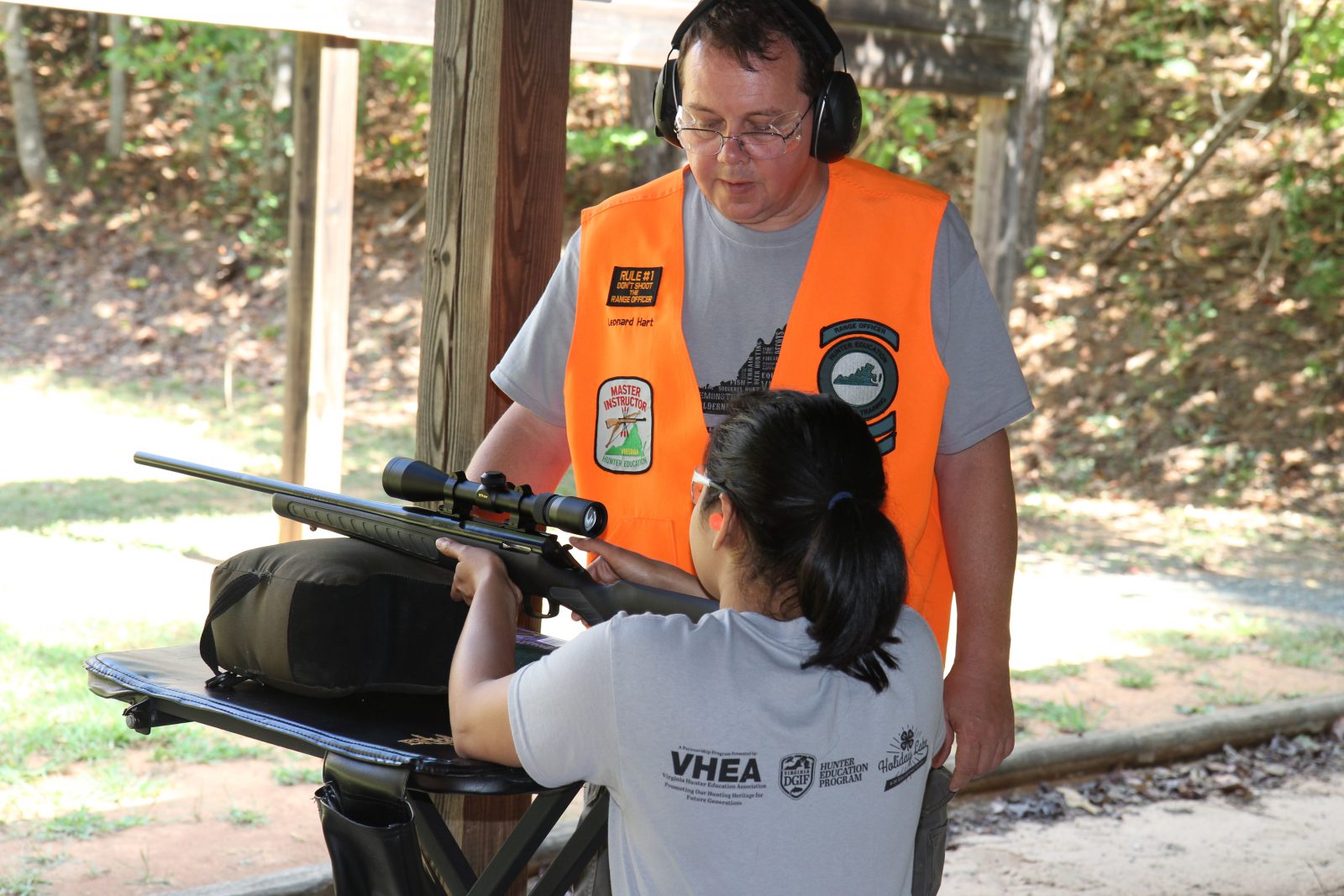 Isang larawan ng isang batang babae na nag-aaral kung paano pumutok ng baril