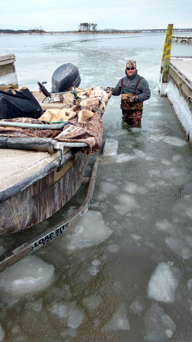Isang imahe ng isang lalaki sa nagyeyelong tubig na tumutulong sa pagdaong ng bangka