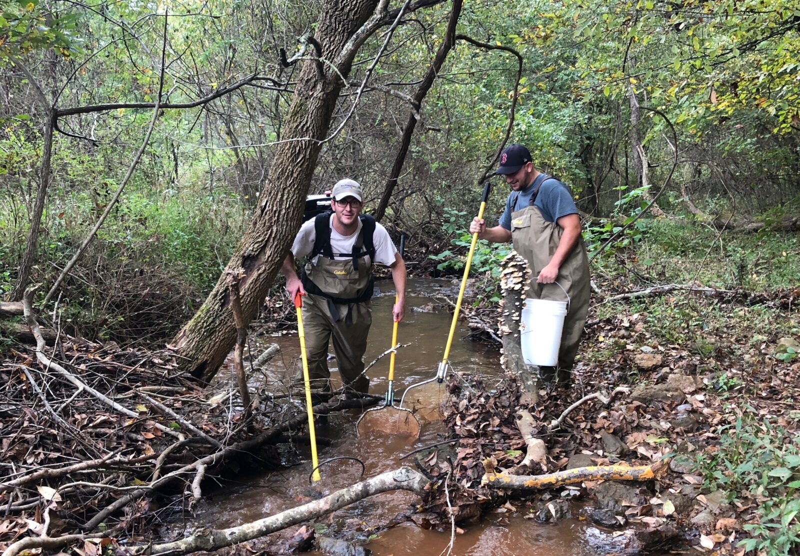 Isang imahe ng dalawang lalaking nage-electrofishing sa isang maliit na sapa gamit ang backpack equipment na kapareho ng sa bangka ngunit mas madaling madala.