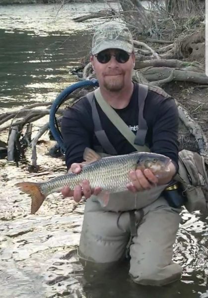 Isang imahe ni Jerry Hall sa isang wetlands na hawak ang kanyang state record sized fallfish