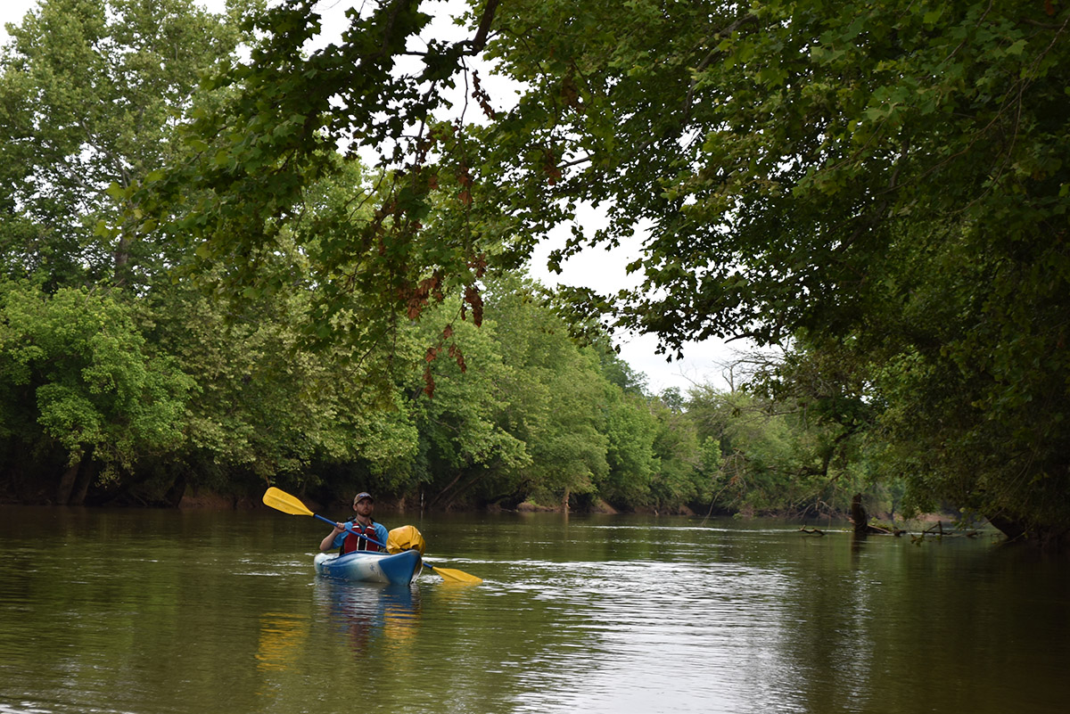 Isang imahe ng isang tao sa isang asul na kayak rafting sa kahabaan ng Rappahannock
