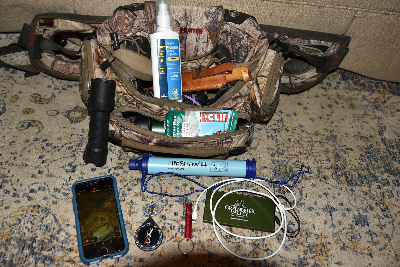 Isang larawan ng isang naka-zipper na pack na may iba't ibang mga item na ipinapakita.