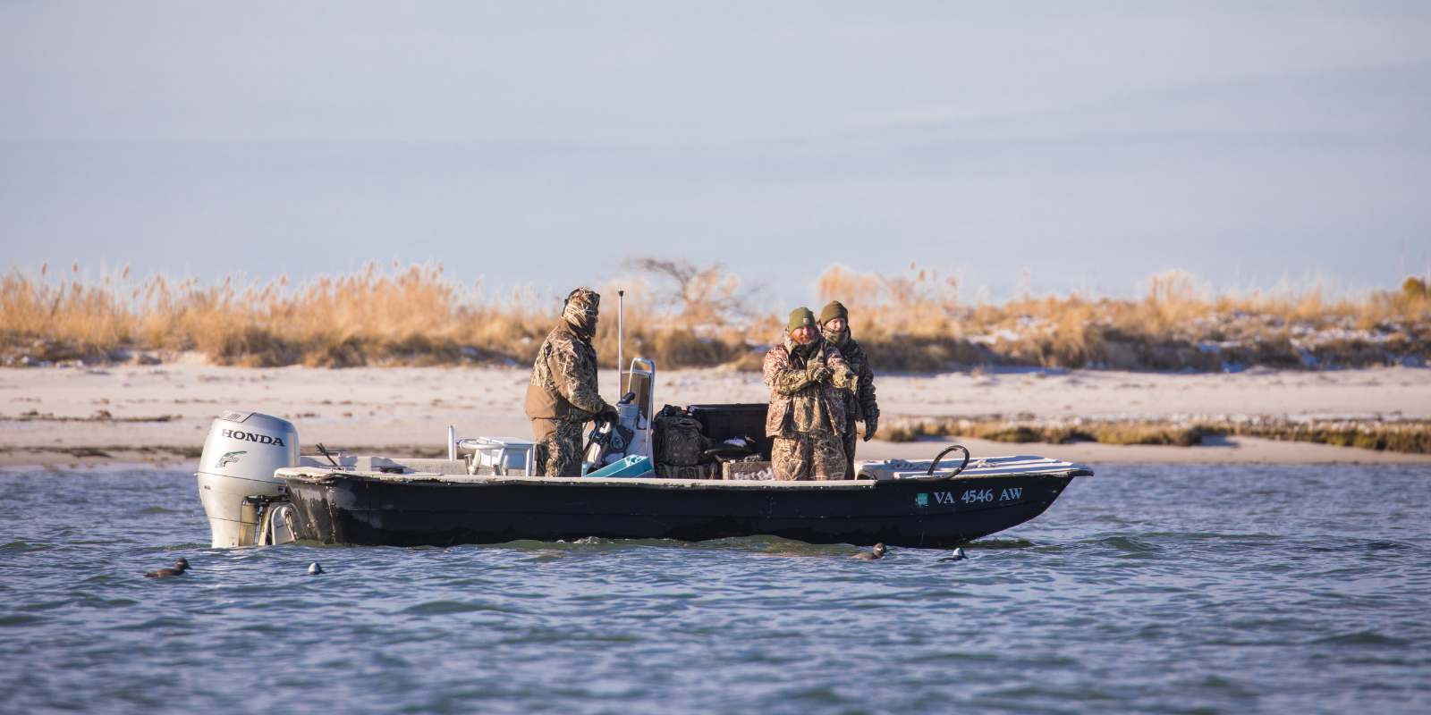 Tatlong tao sa isang bangka sa isang malamig na araw na may mga problema sa makina