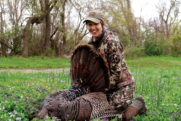Isang imahe ng isang batang babae na nag-pose kasama ang isang patay na pabo