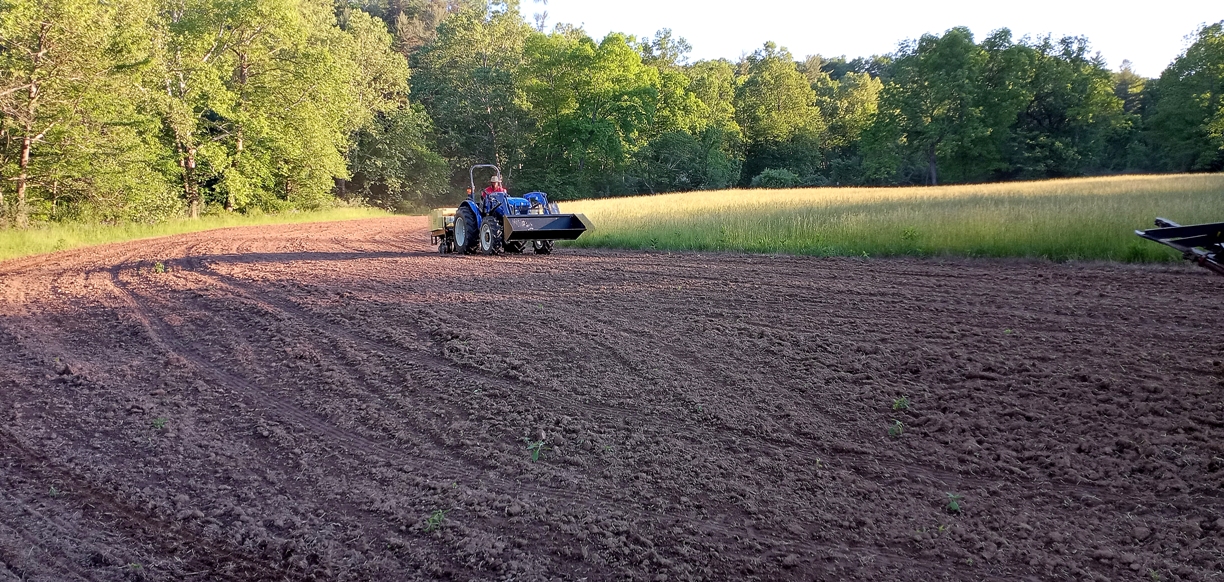 Isang imahe ng isang traktor na naghahasik ng mga buto para sa koridor ng wildlife 