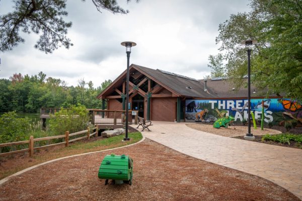 Ang pangunahing pasukan sa Nature Center, na isang kayumangging gusali na may mural na ipininta sa isang gilid na nagsasabing "Tatlong Lawa." Sa kaliwa ng gusali ay isang kubyertang kahoy para sa pagmamasid na tinatanaw ang isa sa mga lawa.